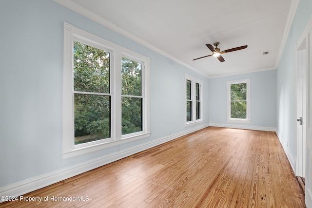 unfurnished room with light wood-type flooring, a wealth of natural light, ceiling fan, and crown molding