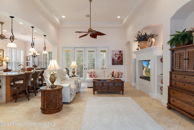 9312 Gentle Ben Ct, Weeki Wachee, FL 34613 - living area with a high ceiling, arched walkways, a ceiling fan, ornamental molding, and a chandelier