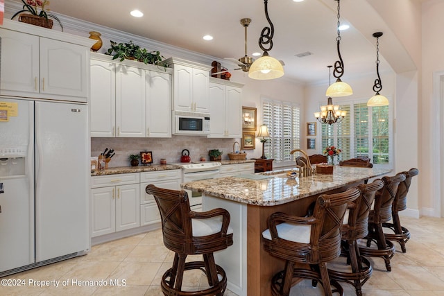 kitchen featuring light stone counters, crown molding, sink, white cabinets, and white appliances