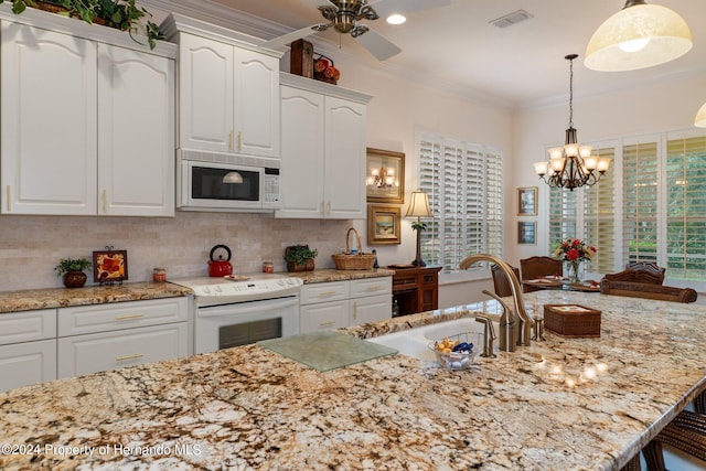 kitchen with white cabinetry, hanging light fixtures, ornamental molding, and white appliances