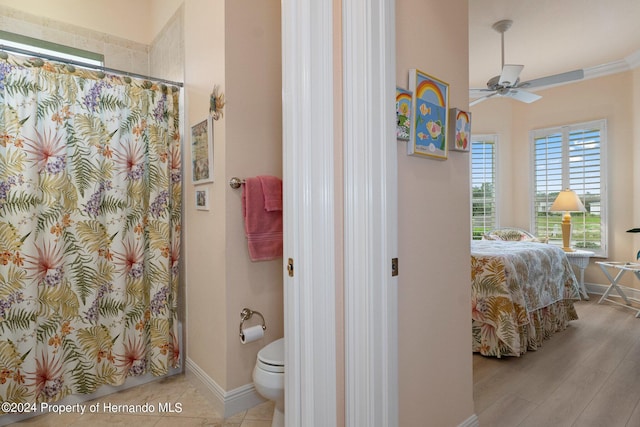 bathroom with hardwood / wood-style floors, walk in shower, ceiling fan, and toilet