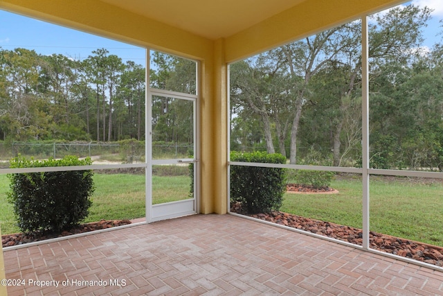 9312 Gentle Ben Ct, Weeki Wachee, FL 34613 - unfurnished sunroom featuring view of scattered trees