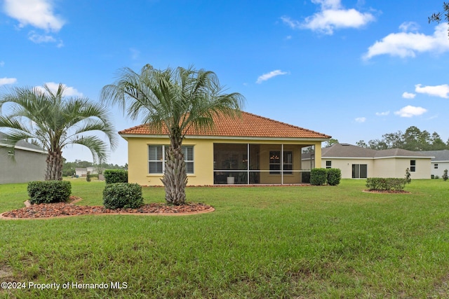 back of house with a sunroom and a yard