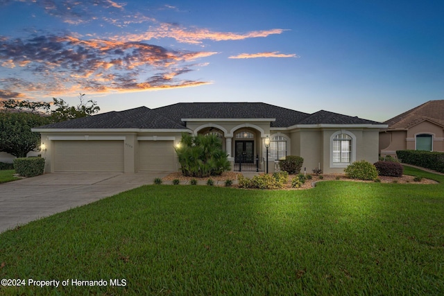 view of front of house featuring a garage and a lawn