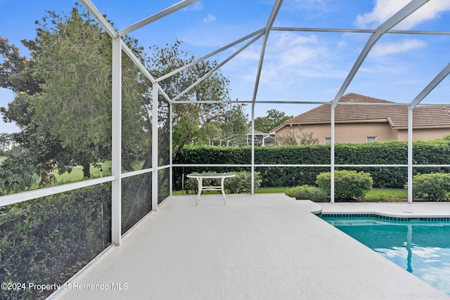 view of pool featuring glass enclosure and a patio area