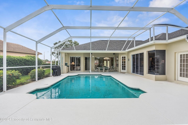 view of swimming pool featuring a patio area, area for grilling, a lanai, and ceiling fan