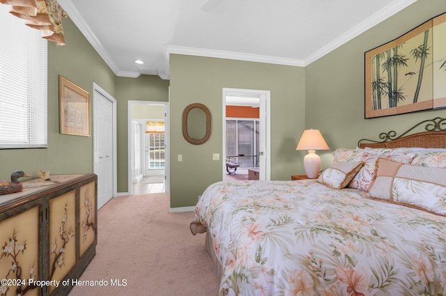 bedroom with ensuite bathroom, light colored carpet, crown molding, and a closet