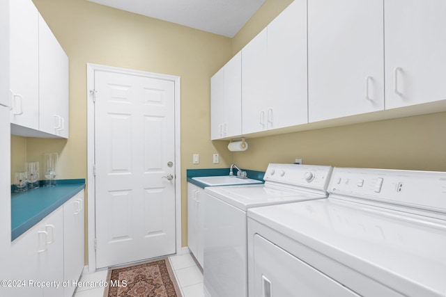 clothes washing area featuring washer and clothes dryer, cabinets, sink, and light tile patterned flooring