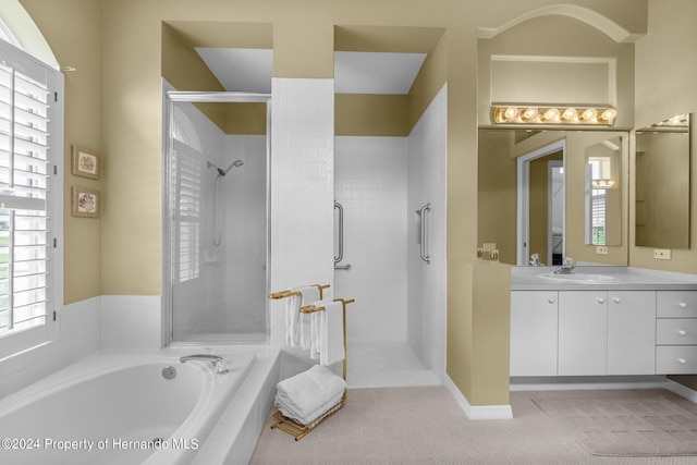 bathroom featuring shower with separate bathtub and vanity