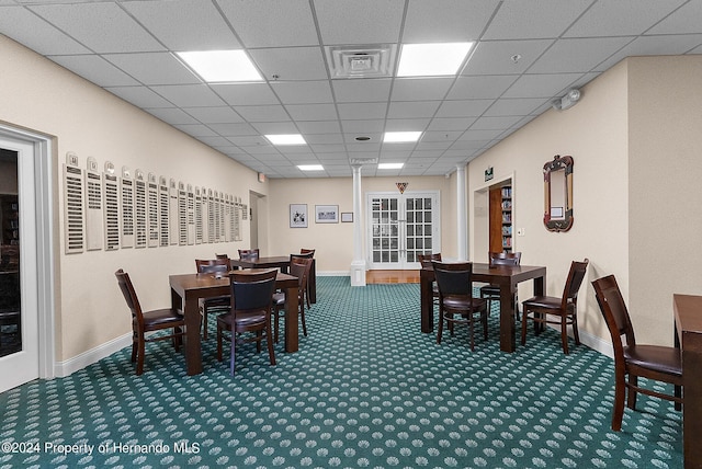 dining area featuring a drop ceiling and carpet flooring