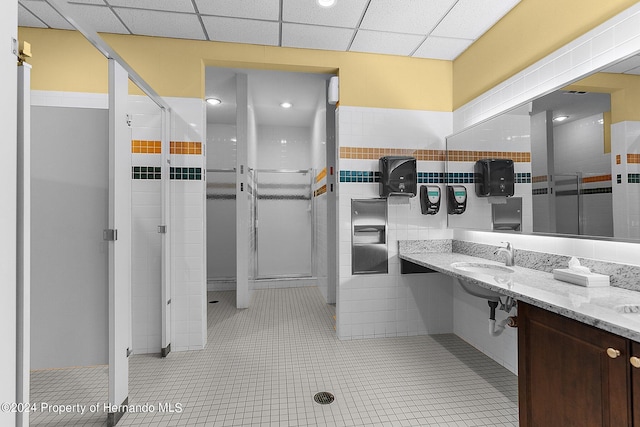 bathroom with walk in shower, a paneled ceiling, and tile patterned flooring