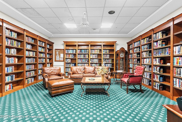 sitting room featuring carpet flooring and a paneled ceiling