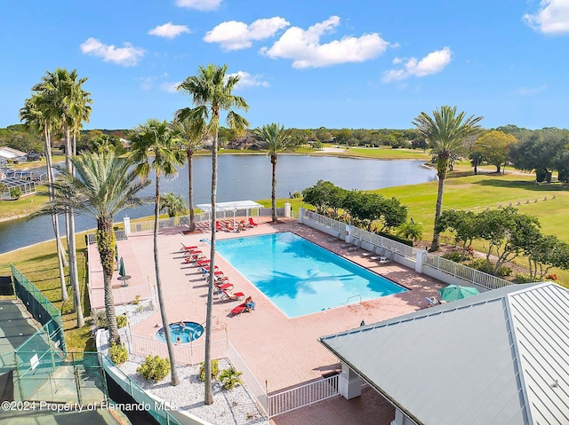 view of swimming pool featuring a patio and a water view