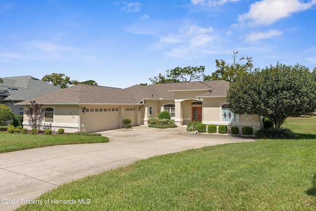 view of front of property with a garage and a front lawn