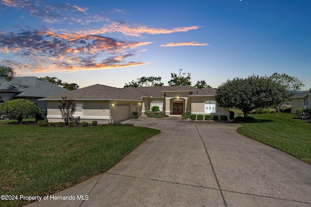 single story home with a garage and a yard