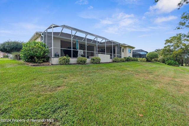 back of house with a yard and a lanai