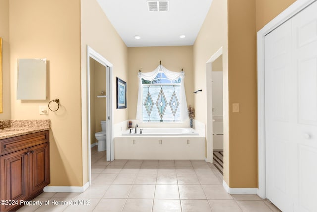 bathroom featuring a bath, tile patterned floors, vanity, and toilet