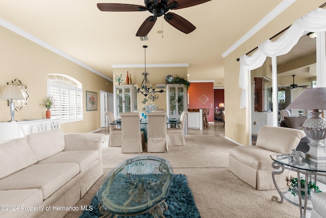 living room with ceiling fan with notable chandelier, crown molding, and light colored carpet