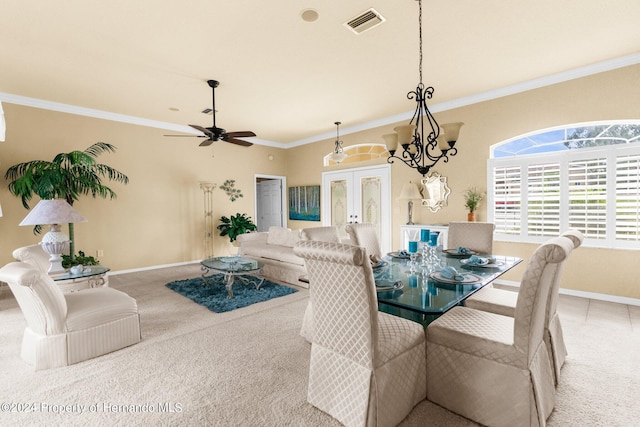 dining space featuring carpet flooring, ceiling fan with notable chandelier, crown molding, and french doors