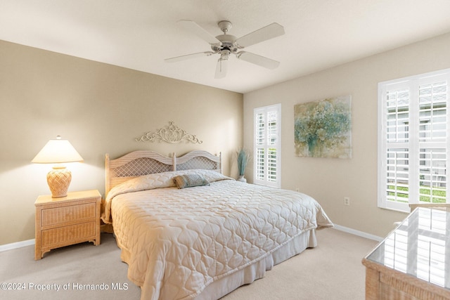 bedroom with ceiling fan, multiple windows, and carpet