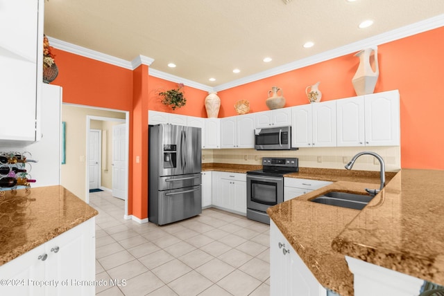 kitchen featuring appliances with stainless steel finishes, sink, white cabinets, dark stone countertops, and kitchen peninsula