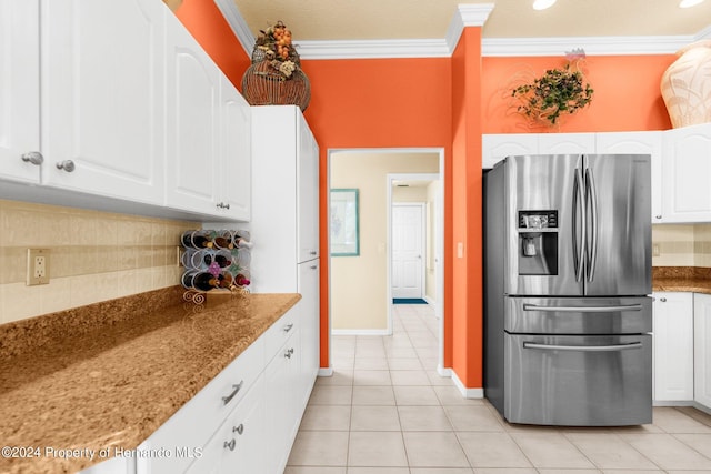 kitchen with dark stone counters, tasteful backsplash, white cabinetry, and stainless steel fridge