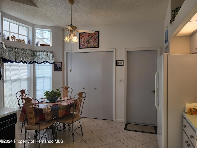 tiled dining area featuring ceiling fan and a textured ceiling