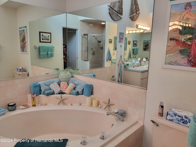 full bathroom featuring vanity, shower with separate bathtub, and toilet