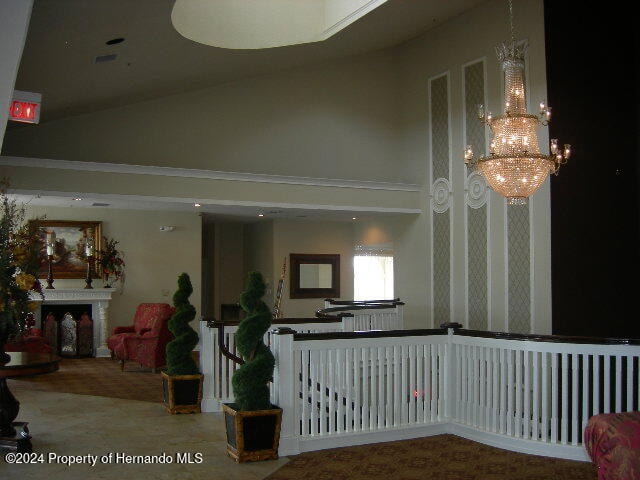 interior space featuring carpet floors, high vaulted ceiling, and a notable chandelier