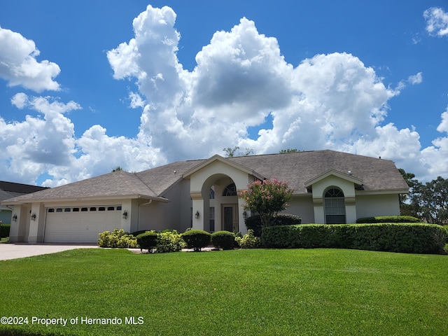 single story home with a front yard and a garage