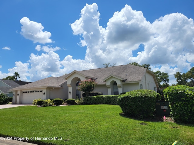 9355 Southern Belle Dr, Weeki Wachee, FL 34613 - single story home featuring stucco siding, a garage, a front lawn, driveway, and a shingled roof