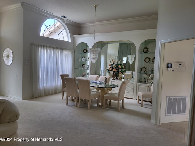 carpeted dining room featuring built in shelves, crown molding, and a chandelier