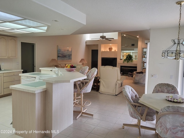 9355 Southern Belle Dr, Weeki Wachee, FL 34613 - kitchen featuring tile countertops, open floor plan, a fireplace, and a kitchen breakfast bar