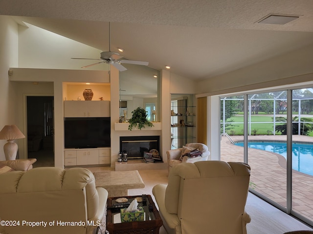 9355 Southern Belle Dr, Weeki Wachee, FL 34613 - living area featuring vaulted ceiling, ceiling fan, and a glass covered fireplace