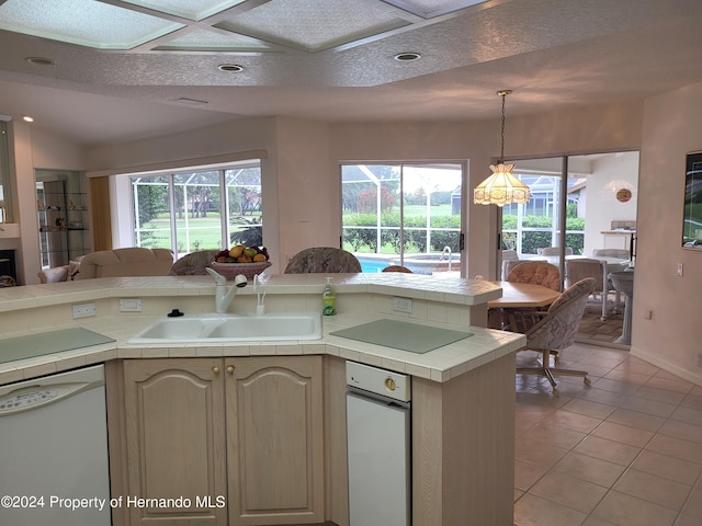 kitchen featuring sink, dishwasher, light tile patterned floors, tile counters, and a chandelier