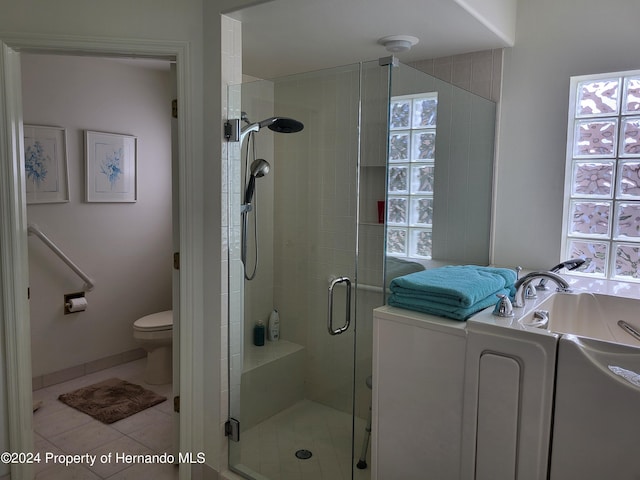 bathroom featuring toilet, an enclosed shower, and tile patterned flooring