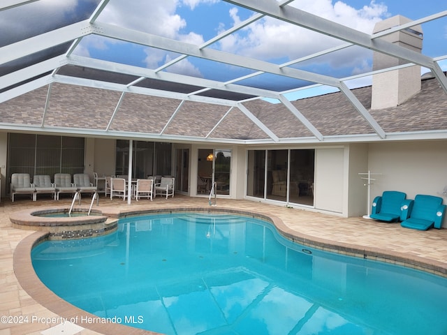 view of pool featuring a lanai, a patio, and an in ground hot tub