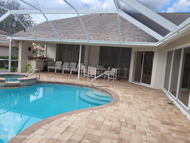 view of swimming pool with a lanai, a patio, and an in ground hot tub