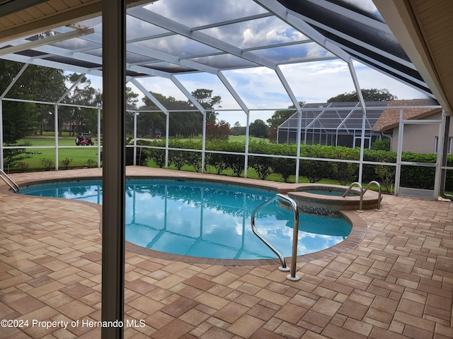 view of swimming pool with a lanai, a patio, and an in ground hot tub