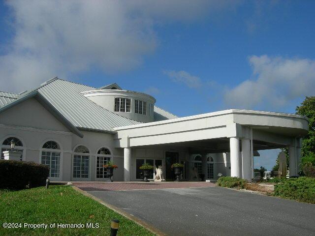 9355 Southern Belle Dr, Weeki Wachee, FL 34613 - view of front facade featuring stucco siding and metal roof