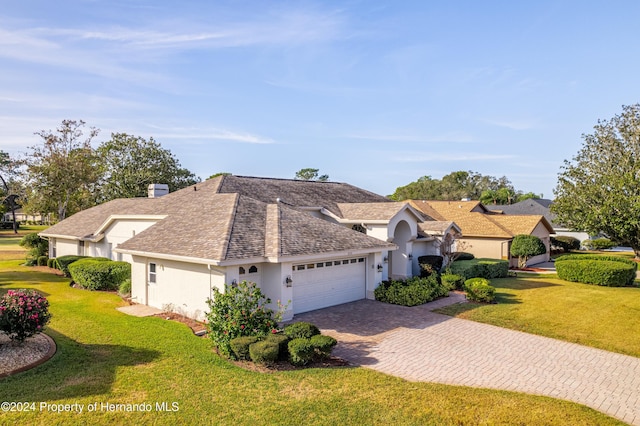 view of front of home with a front yard and a garage