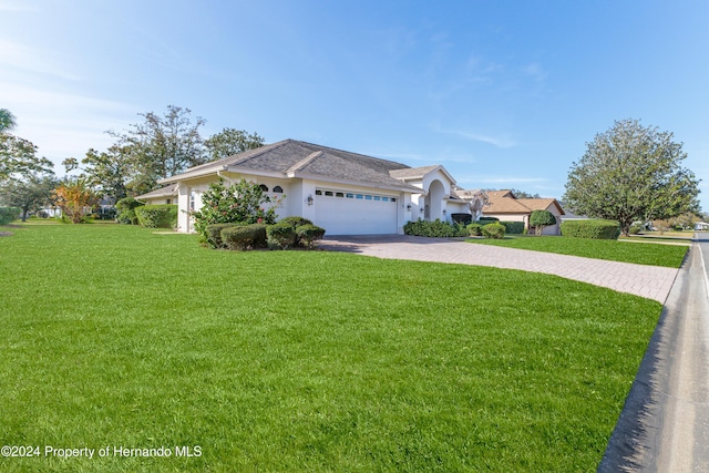 ranch-style home featuring a garage and a front lawn