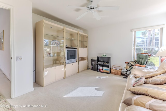 carpeted living room with ceiling fan