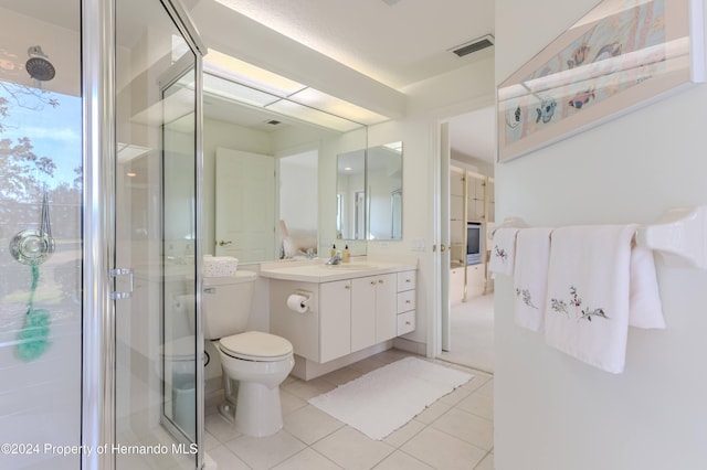 bathroom with toilet, vanity, tile patterned flooring, and a shower with shower door