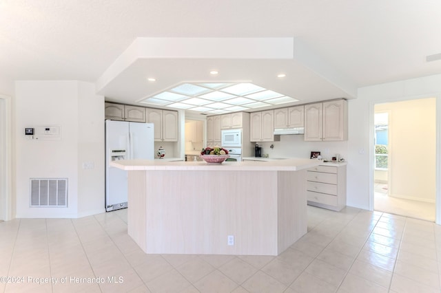 kitchen featuring a kitchen island, white appliances, and light tile patterned floors