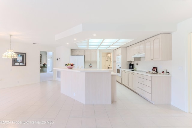 kitchen featuring light tile patterned floors, white appliances, a center island, and pendant lighting