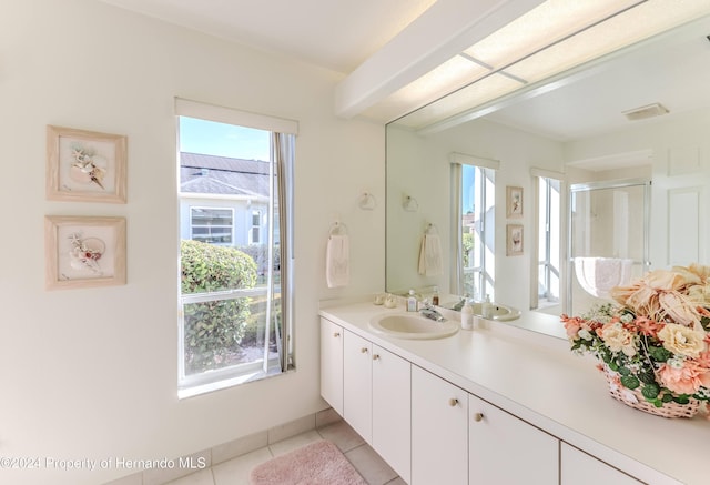 bathroom with tile patterned flooring, a shower with shower door, and plenty of natural light