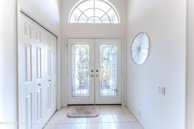 tiled foyer with french doors and a high ceiling