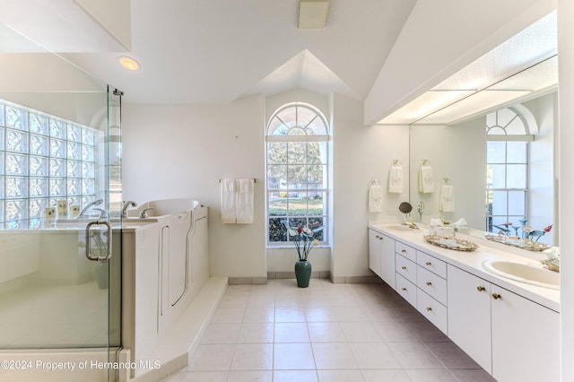 bathroom with a shower with door, vaulted ceiling, tile patterned floors, and vanity