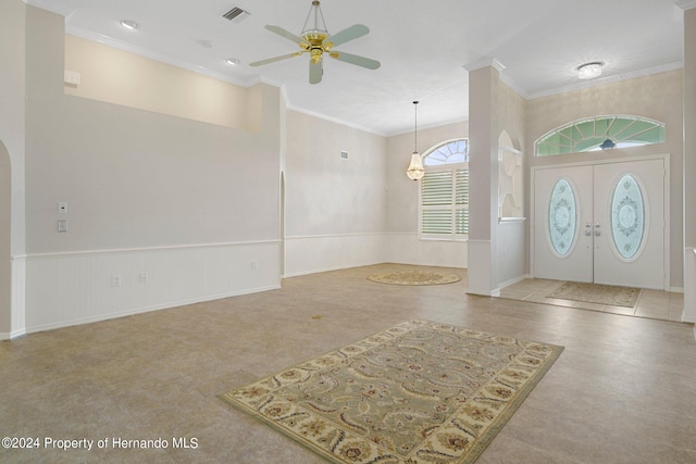 entrance foyer featuring french doors, ceiling fan, and crown molding